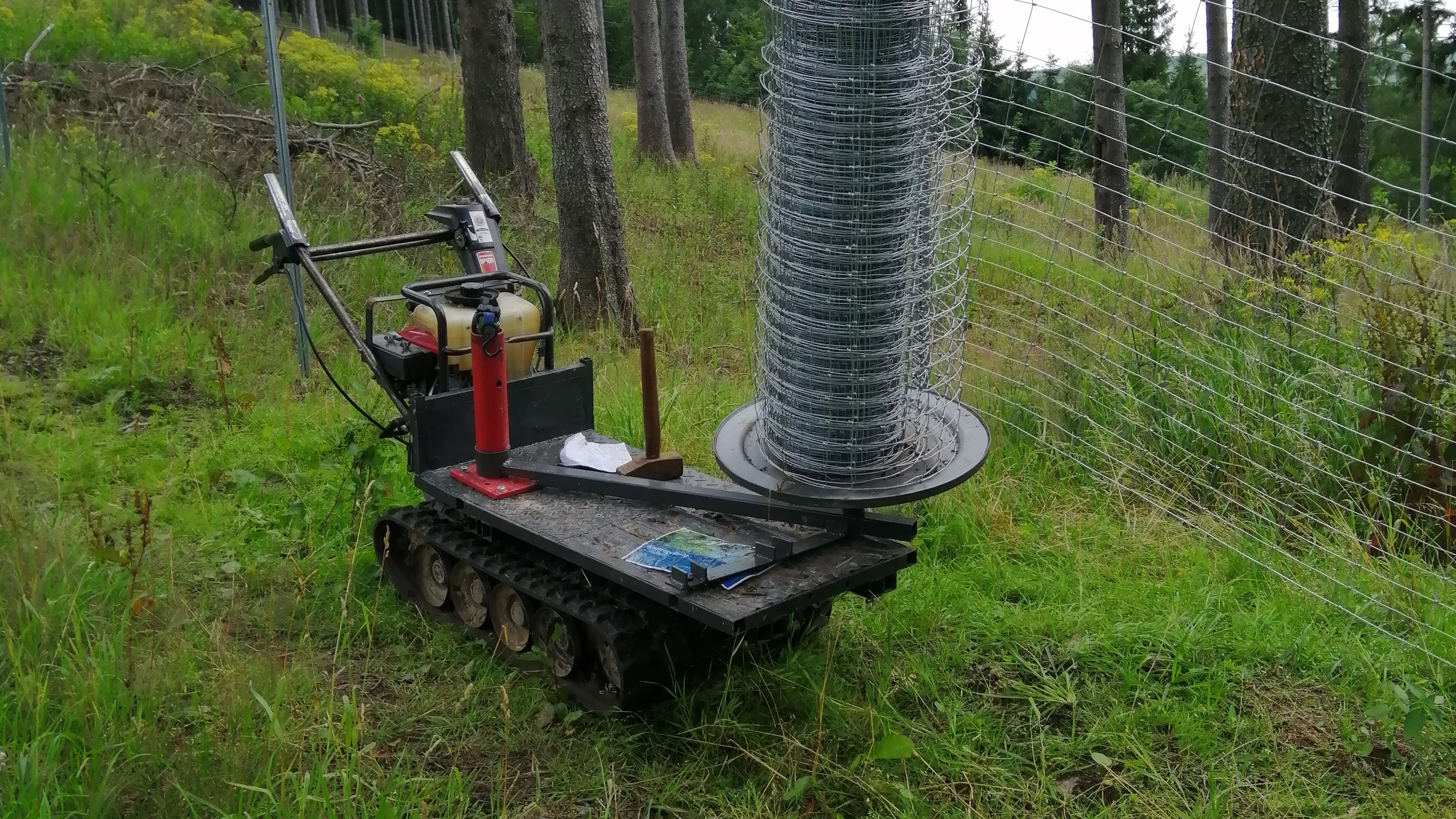 Zu sehen ist unsere Kettenraupe mit selbstgebauter Abspulvorrichtung für Wildschutzzaun